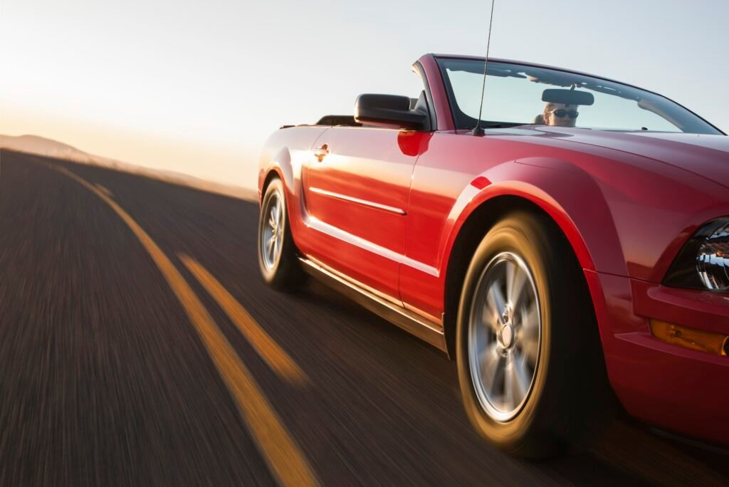 a low angle view of a convertible sports car moving on a highway late in the day .jpg