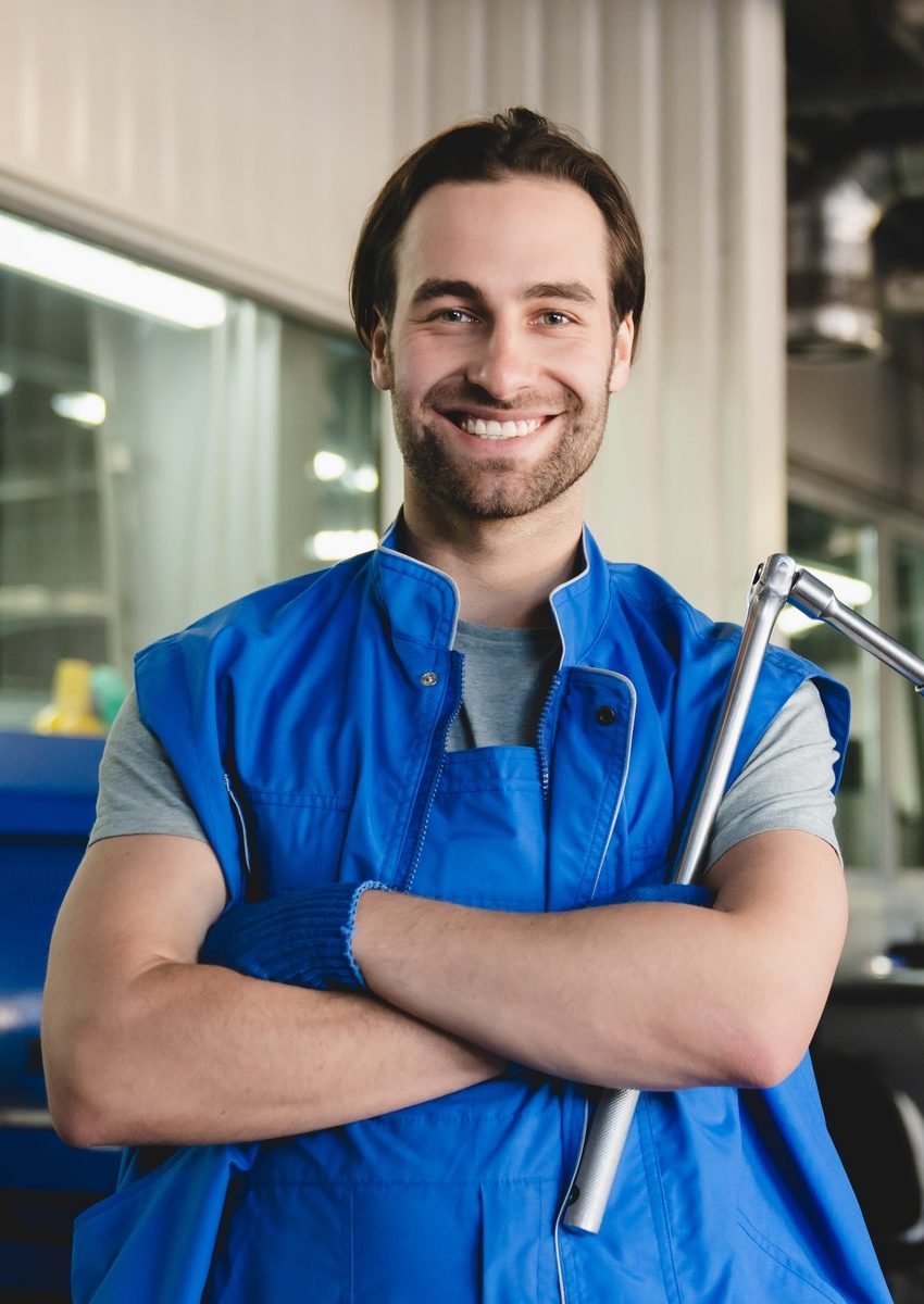 technician mechanic holding pipe monkey wrench looking at camera at vehicle service inspection e1651039632664.jpg